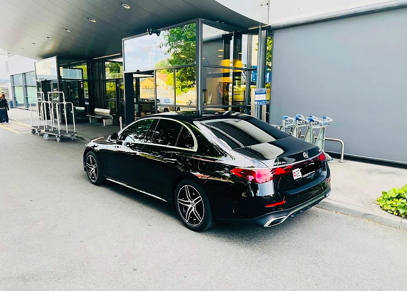 Berline Mercedes noire devant un terminal