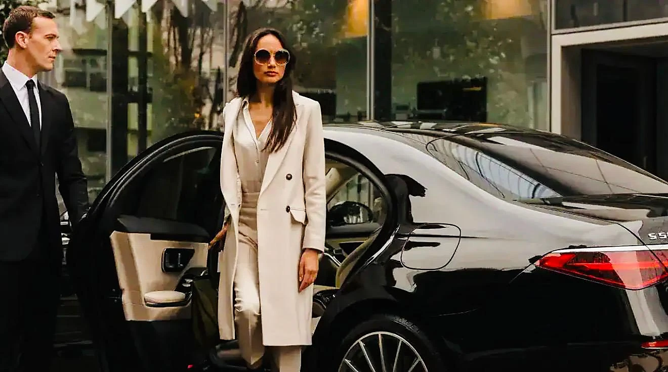 Chauffeur en costume ouvrant la portière à une passagère