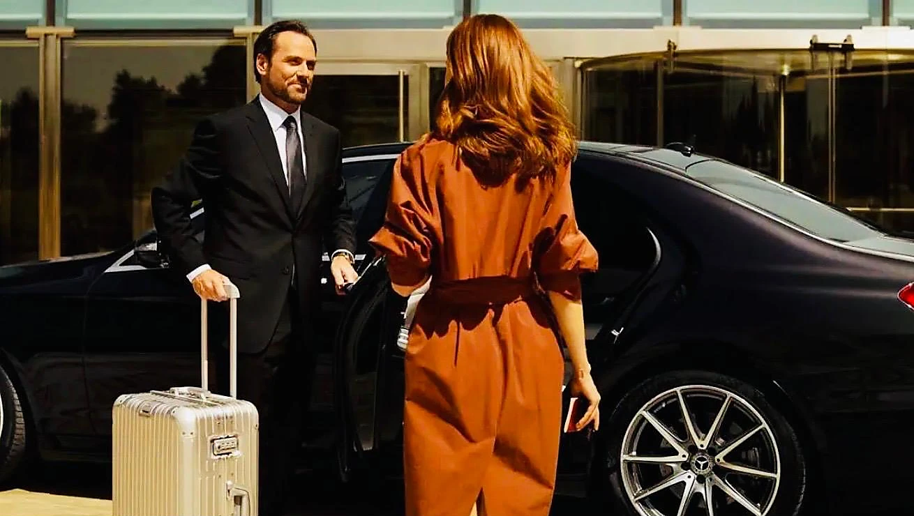 Chauffeur prenant en charge les bagages d’une passagère